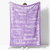 Lavender throw blanket with ’madeleine’ repeated in various fonts and sizes on a soft, plush material.