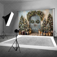 Aperturee - Aperturee Rustic Blue Door Holiday Backdrop with Festive Garland and Snow-Dusted Christmas Trees Elegant Gifts and Lanterns