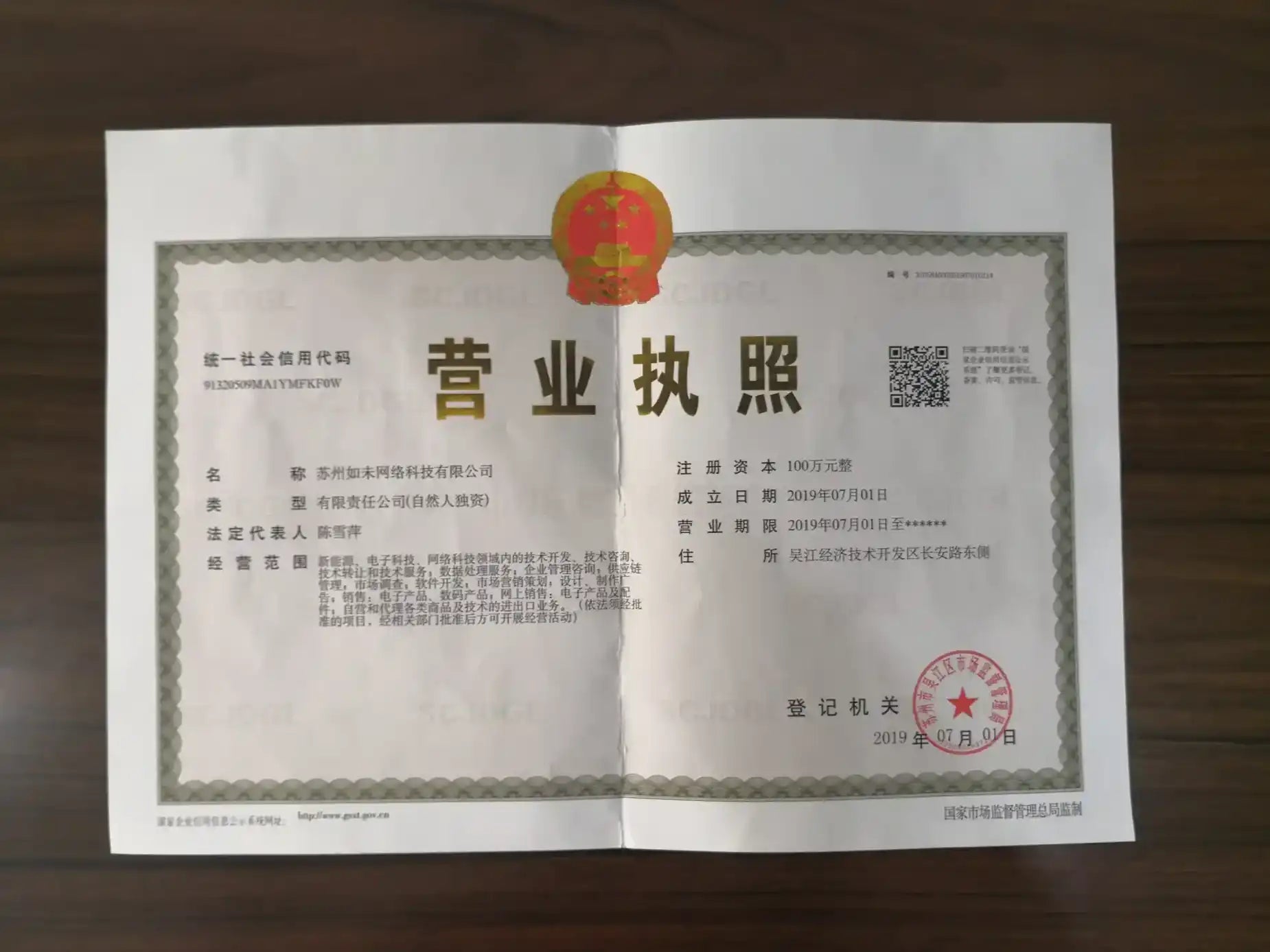 Business license document with red and gold seal, white background.